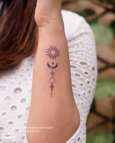 a woman's arm with a tattoo on it and the sun in the background