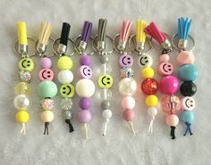 several key chains with smiley faces and other items attached to them on a white surface