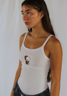 With three hand-sewn pink bows, the Hugging Bears embroidered top is a must-have piece.   Model is wearing a size small White Tank Crop Top For Streetwear, Fitted Graphic Print Cute Tank Top, Fitted White Y2k Tank Top, White Fitted Y2k Tank Top, White Y2k Cotton Tank Top, White Cotton Y2k Tank Top, White Cotton Y2k Style Tank Top, Cute White Fitted Crop Top, Cute Fitted White Crop Top