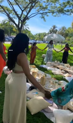 people standing around a table with food on it