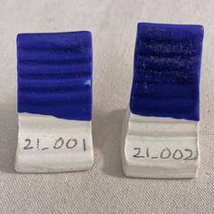 two blue and white ceramic bookends sitting on top of a cloth covered floor