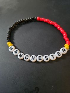 Manchester United Soccer Beeded Bracelet.  Soccer themed Avaliable in multiple colors, size. Adjustable Themed Bracelets With Letter Beads, Handmade Red Beaded Bracelets In Novelty Style, Handmade Red Beaded Bracelets, White Themed Beaded Bracelet, Customized Themed Bracelets, Black Novelty Bracelets With Round Beads, Novelty Letter Beads Wristband Bracelet, Black Round Beads Novelty Bracelet, Adjustable Beaded Bracelets With Letter Beads As Souvenir