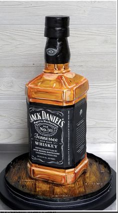 a bottle of jack daniels whiskey sitting on top of a wooden tray with a black lid