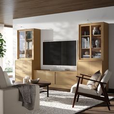 a living room filled with furniture and a flat screen tv on top of a wooden entertainment center