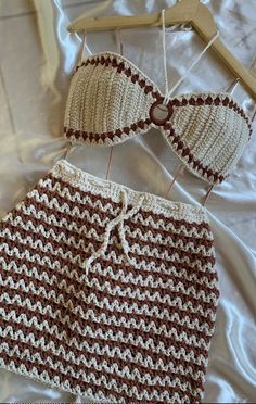 two pieces of crocheted clothing on a bed