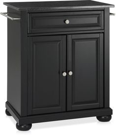 a black kitchen island with granite top and two doors on one side, in front of a white background