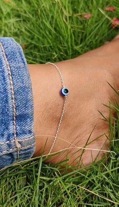 The Evil Eye Anklet is a unique piece of jewelry that is said to offer protection and bring good luck to its wearer. PRODUCT DETAILS - MATERIAL - 925 Sterling Silver (Pure Silver) FINISH TONE - 18k White Rhodium GEMSTONE - Blue Evil Eye STONE SIZE - 6mm ANKLET LENGTH - 8.5" + 0.75" Adjustable WEIGHT - 3 gms approx. ABOUT GEMSTONE -  The Evil Eye Anklet is not only a fashionable accessory but is also associated with a variety of benefits: 1.Protection: It is said to guard the wearer from negative 925 Silver Anklets, Silver Minimalist Anklets For Gift, Silver Spiritual Anklets As Gift, Sterling Silver Anklet With Silver Chain For Gift, Sterling Silver Chain Anklet For Gift, Sterling Silver Anklets With Silver Chain As Gift, Handmade Silver Anklets As A Gift, Minimalist Hypoallergenic Sterling Silver Anklets, Adjustable Hypoallergenic Sterling Silver Anklets