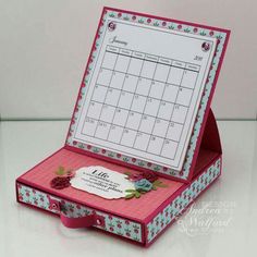 an open pink box with a calendar inside