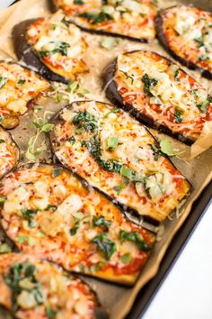 sliced eggplant and cheese pizzas on a baking sheet