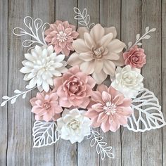 the paper flowers are arranged on top of each other in pink, white and beige colors