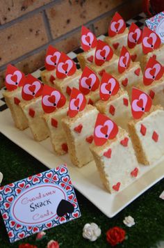 there are many small pieces of cake on the plate with red paper hearts in them