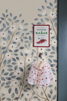 there is a wall paper with leaves on it and a bird hanging from the tree