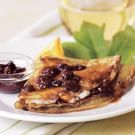 a white plate topped with quesadillas covered in raisins and sauce