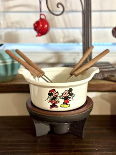 a mickey mouse bowl with cinnamon sticks sticking out of it