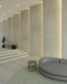 a living room filled with lots of white walls and flooring next to a round couch