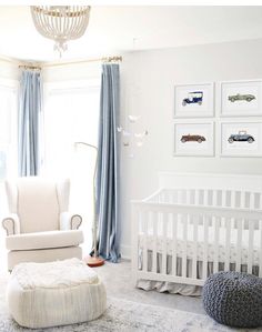 a baby's room with white furniture and blue curtains