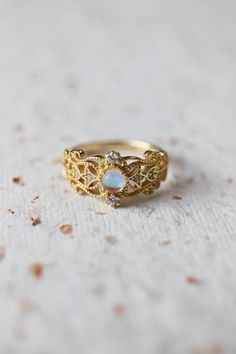 Sonia Moonstone Floral Gold Lace Filigree 18K Gold Vermeil Ring features moonstone in the centre, accented by lace filigree on the sides. It is similar to Monique Moonstone Ring in our shop, but the details of the ring are different. This is an adjustable ring, it comes in one size only and fits US ring size 5 to 8. ◊ 18K Gold Vermeil ◊ Adjustable Ring ◊ Sold in ONE SIZE only ◊ Fits US ring size 5 to 8 ◊ Lab Moonstone and cubic zircons ◊ Delivered in our signature royal blue box, it makes the pe Mystical Yellow Gold Jewelry For Anniversary, Celestial Moonstone Rings With Gemstone Accents, Magical Round Moonstone Ring For Wedding, Mystical Gold Round Rings, Celestial Moonstone Ring With Gemstone Accents For Wedding, Gold Moonstone Rings With Gemstone Accents, Gold Moonstone Ring With Gemstone Accents For Anniversary, Gold Rings With Gemstone Accents And Moonstone, Ethereal Gold Ring Perfect As Gift