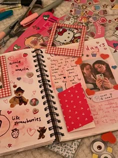 an open notebook with pictures and stickers all over it on a bed next to scissors