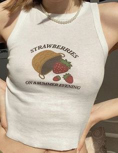 a woman wearing a white tank top with strawberries on it