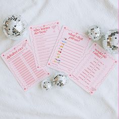 three pink and silver party game cards on a white sheet with disco balls around them