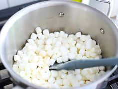 a pot filled with marshmallows on top of a stove