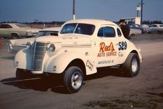 an old white truck with red's auto service painted on the side parked in a parking lot