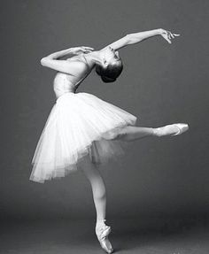 the ballerina is posing in her white tutu