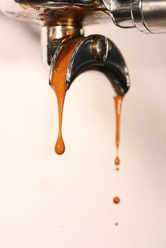 dripping caramel colored liquid coming out of a faucet