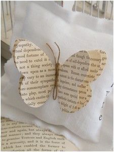 a white pillow with a butterfly cut out of it's back on top of a book page