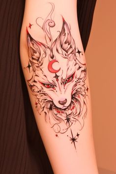 a woman's arm with a tattoo on it that has an image of a wolf and stars