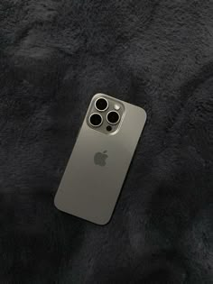 an iphone case sitting on top of a black fur covered surface with four holes in the back