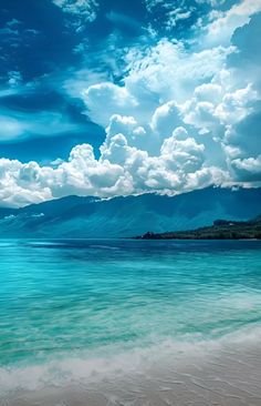 an ocean view with clouds in the sky and some water on the beach below it