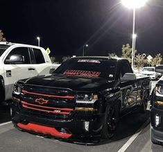 two trucks parked in a parking lot at night