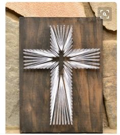 a cross made out of sticks sitting on top of a wooden board