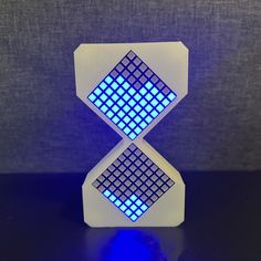 an illuminated object sitting on top of a black table next to a blue light in the middle