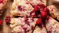 raspberry scones on a cooling rack with butter and strawberries next to them