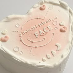 a heart shaped cake with white frosting and pink icing that says, finder for baking face