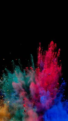 colorful powder is thrown into the air on a black background