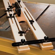 a close up of a table sawing on a piece of wood with two different tools