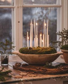 a bowl filled with candles sitting on top of a table