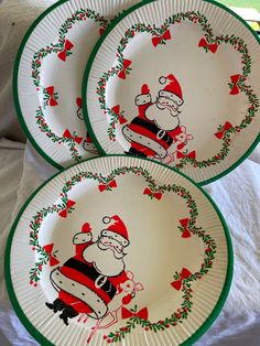 three christmas plates with santa clause on them