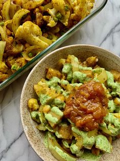 two bowls filled with food sitting on top of a marble counter next to each other