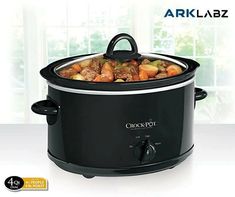 an electric slow cooker with food in it on a white countertop next to a window