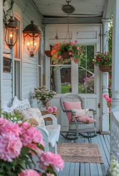 the porch is decorated with pink flowers and wicker furniture