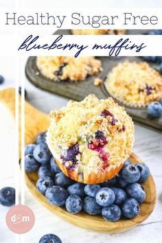 blueberry muffins on a wooden plate with fresh blueberries