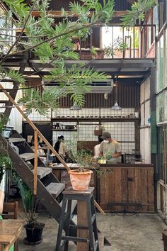 an industrial kitchen with stairs and plants in the center, surrounded by potted plants