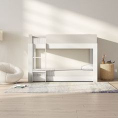 a white bunk bed sitting on top of a hard wood floor next to a chair