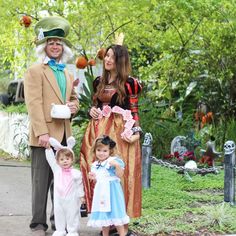 three people dressed up in costumes posing for a photo with two small children and one adult