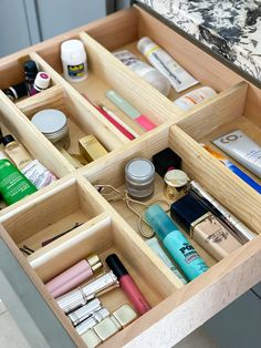 an open drawer filled with cosmetics and other personal care items on top of a counter