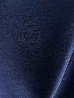 an upholstered blue velvet fabric with intricate designs on the back and sides, closeup